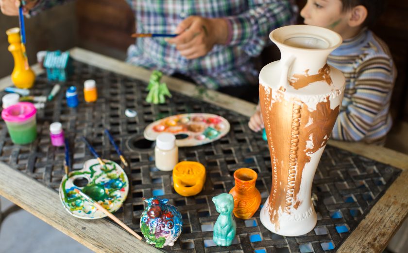 Father and son paint a vase