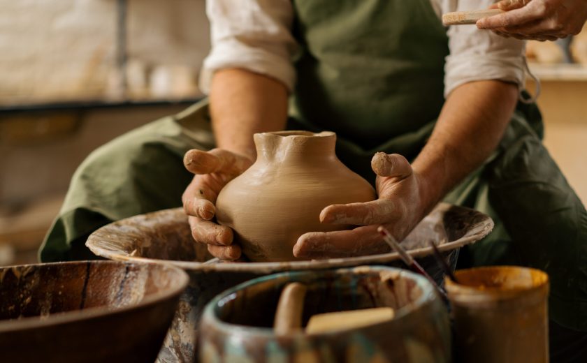 Pottery workshop a potter teaches student to sculpt jug from clay couple is engaged in pottery